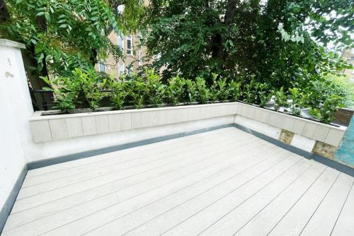 Millboard Enhanced Grain, Limed Oak, Floating Flower Bed With Cherry Laurel Hedging.  